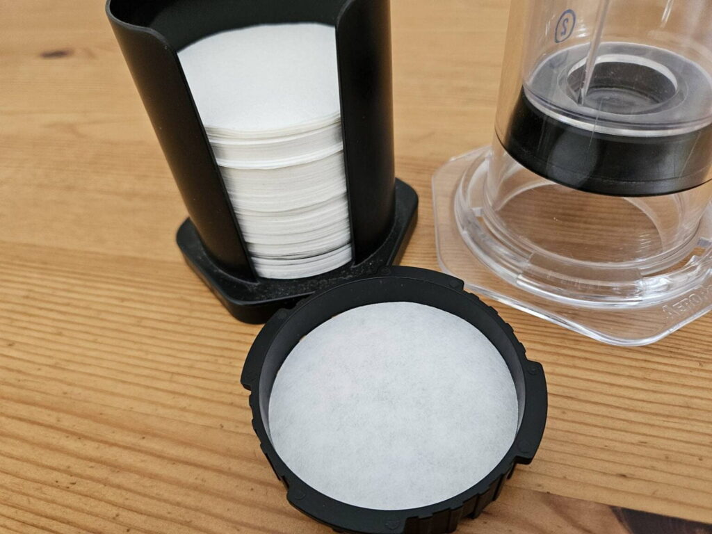 AeroPress Paper Filter AeroPress paper filters in a filter holder, and in the cap filter